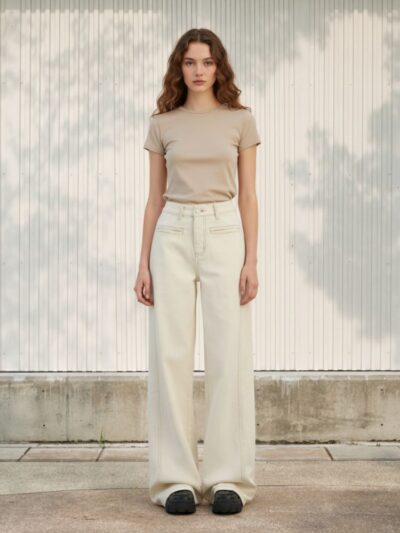 Femme portant un t-shirt crop beige avec un jean baggy beige, sur fond clair