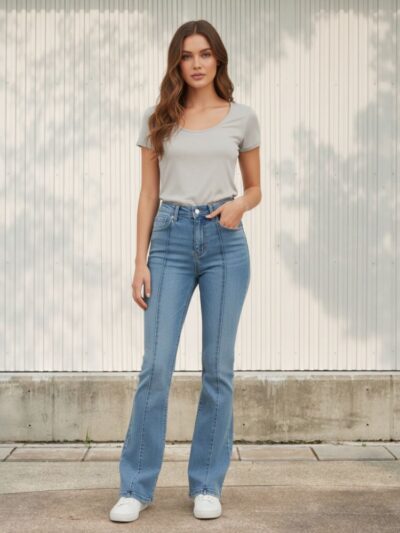 Femme portant un t-shirt gris avec un jean boocut à taille haute et avec une couture apparente sur le devant, sur fond clair