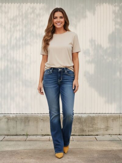 Femme portant un t-shirt gris et un jean bleu délavé au style vintage, sur fond clair
