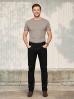 Homme portant un t-shirt gris avec un jean slim noir élégant, sur fond clair