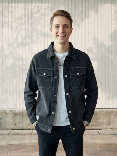 Homme portant un t-shirt blanc avec une veste en jean noir façon surchemise, sur fond clair