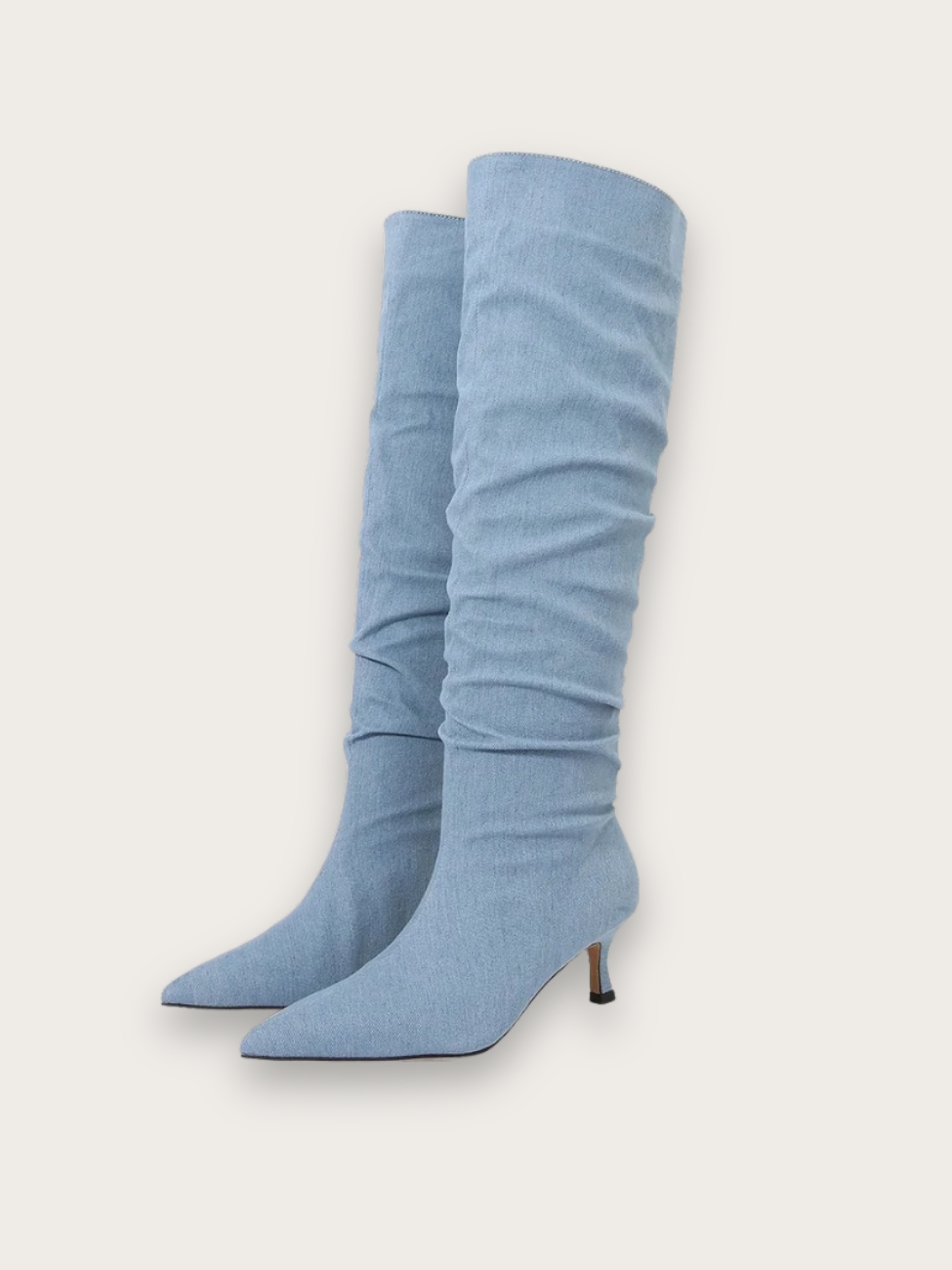 Bottes en jean bleu clair plissé, sur fond gris