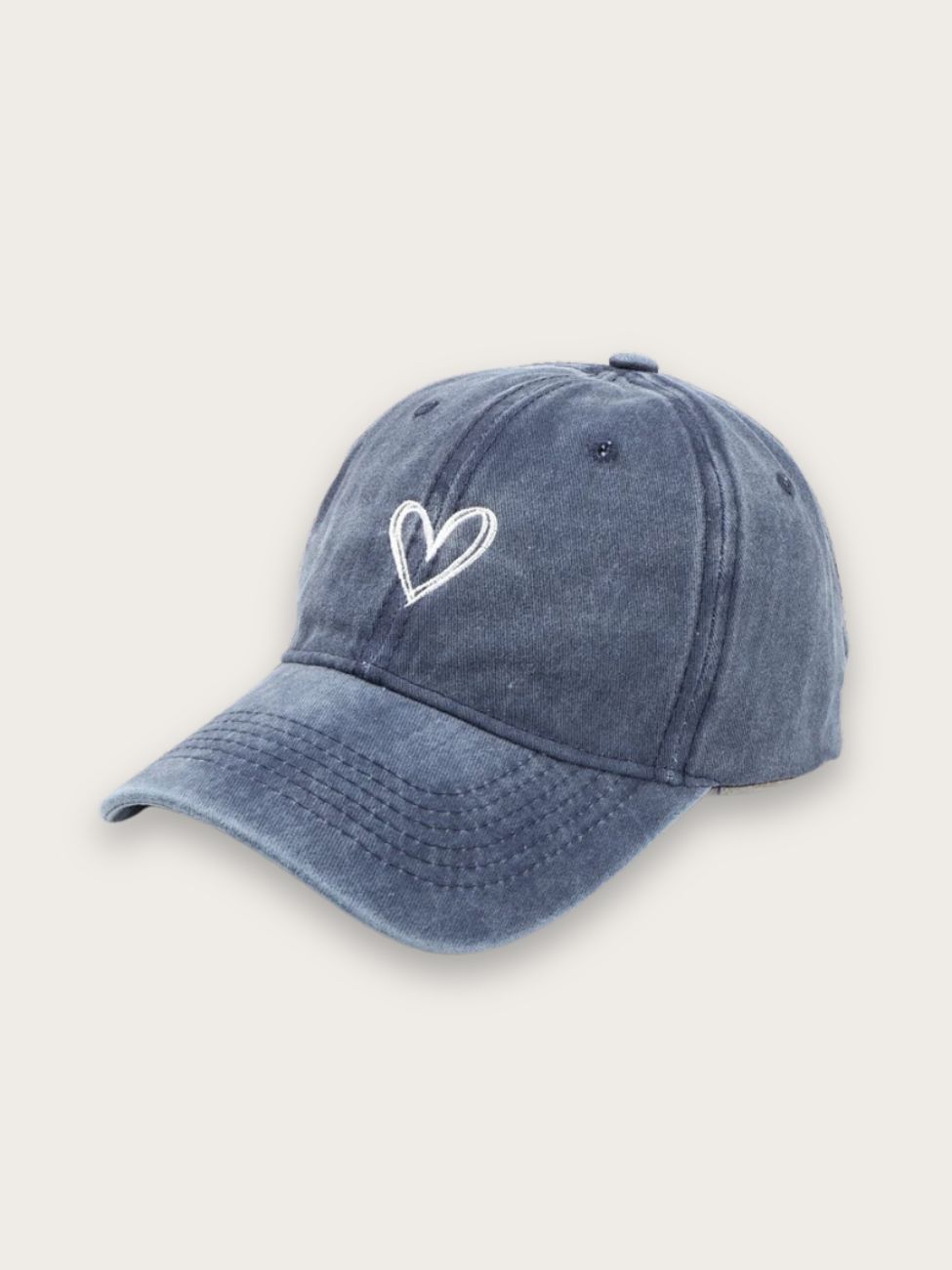 Casquette en jean bleu avec une broderie coeur blanche, sur fond gris