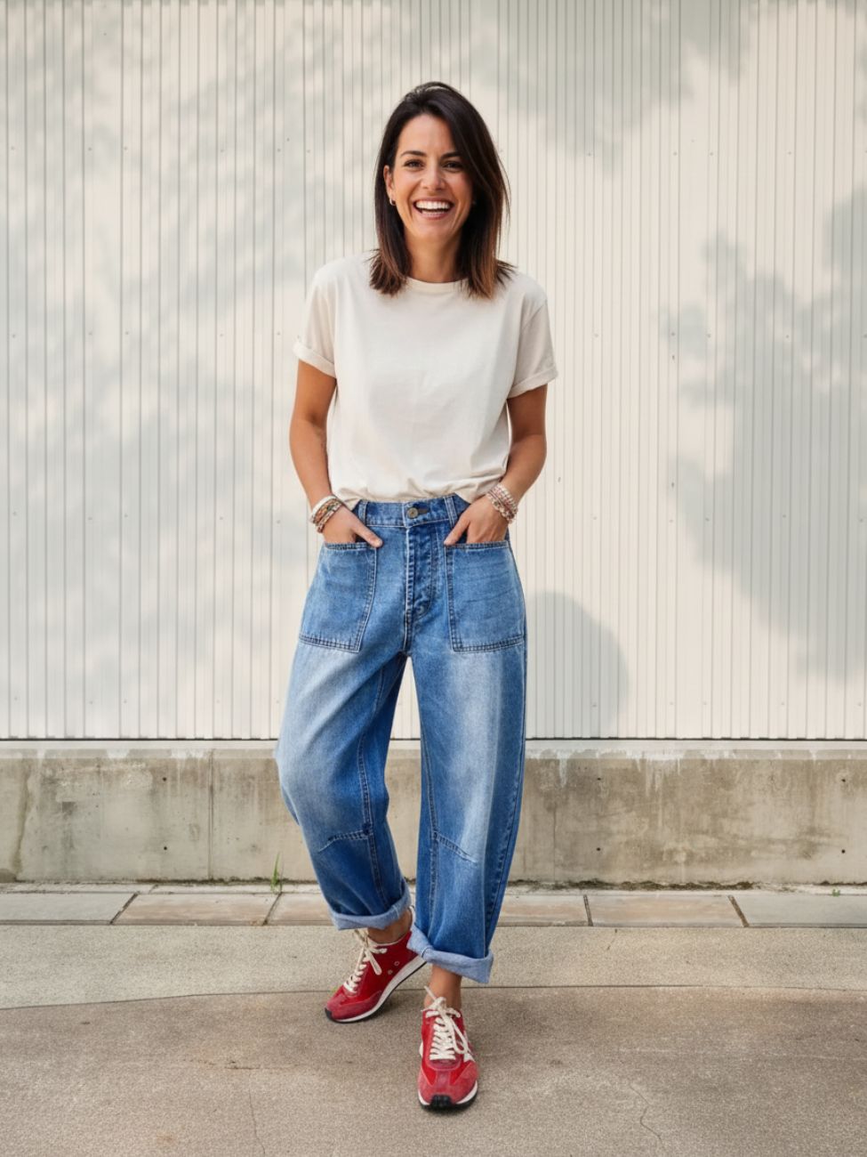 Femme portant un t-shirt blanc avec un jean court bleu délavé à ourlet, sur fond beige