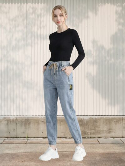 Femme portant le jean jogger femme 7/8 en denim stretch à taille élastiquée : coupe décontractée, tissu souple, chevilles dégagées, parfait pour l’hiver actif.