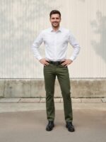 Homme portant une chemise blanche avec un jean vert kaki, sur fond beige