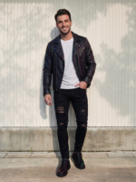 Jean moto homme noir déchiré slim stretch porté par un homme, coupe ajustée, denim noir destroy, style motard urbain, silhouette fine, look rebelle moderne.