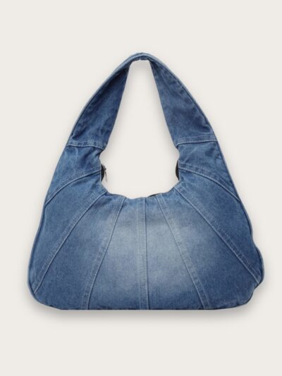 Sac à main en jean style vintage porté épaule, sur fond gris