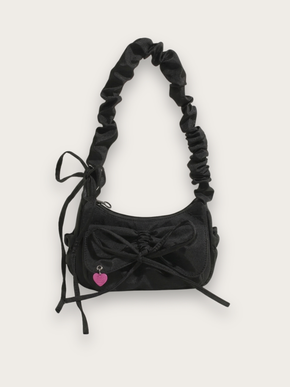 Sac à main en jean noir porté épaule avec un noeud et une anse scrunchie, sur fond gris