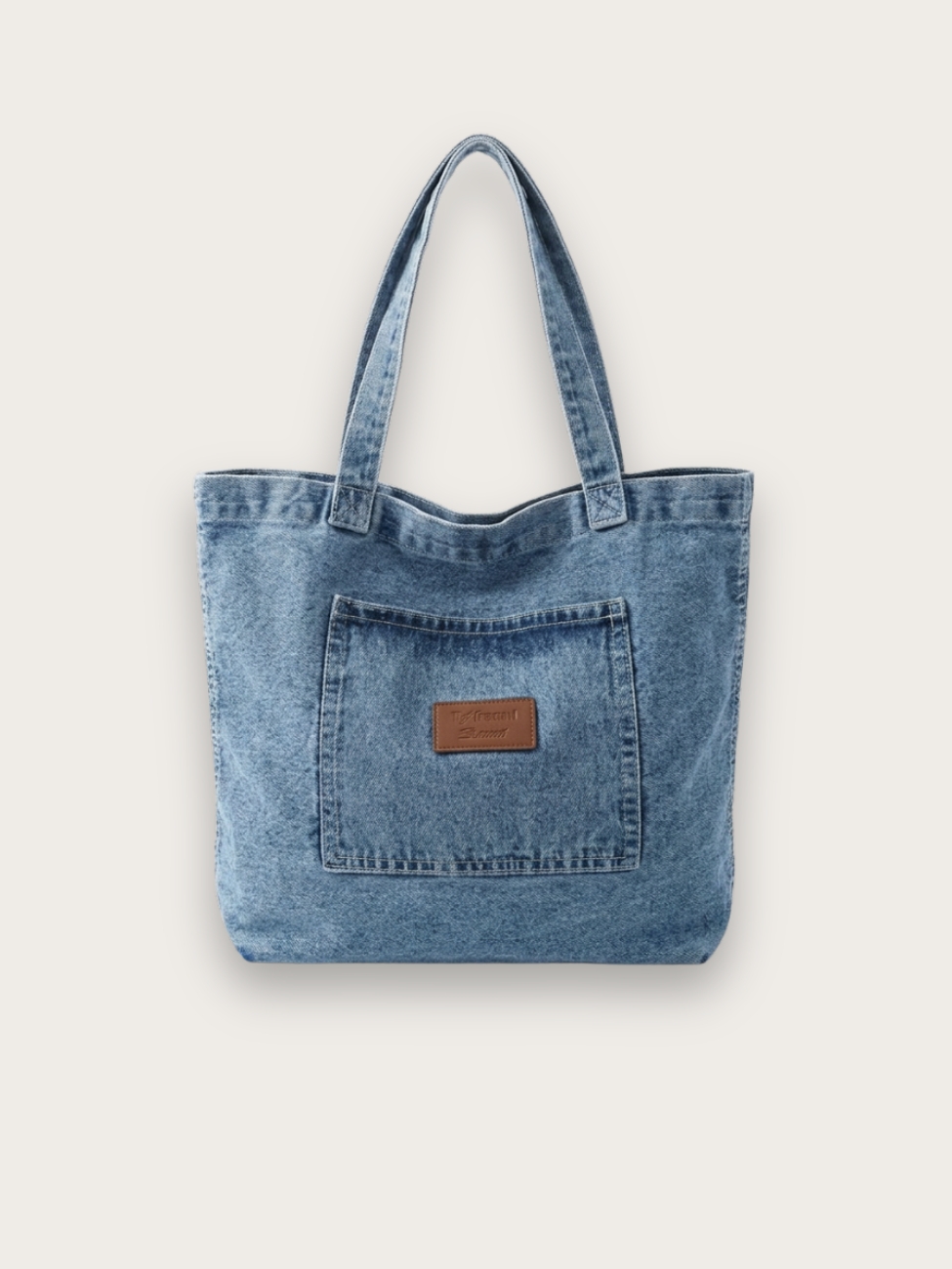 Sac à main tote bag porté épaule en jean, sur fond gris