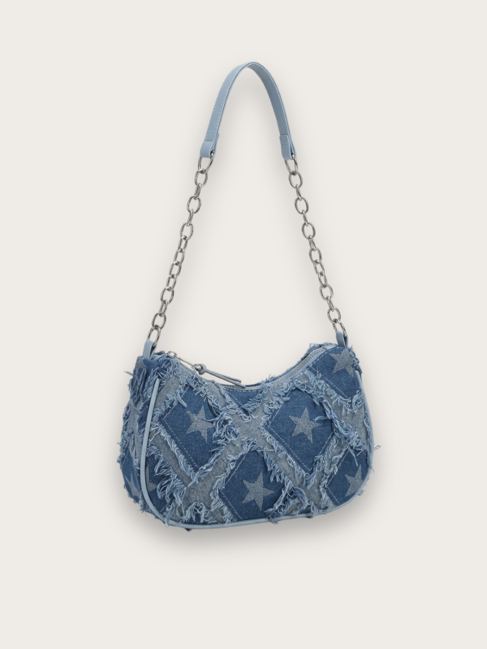 Sac à main en jean porté épaule à patchwork étoiles et avec une anse en chaîne, sur fond gris